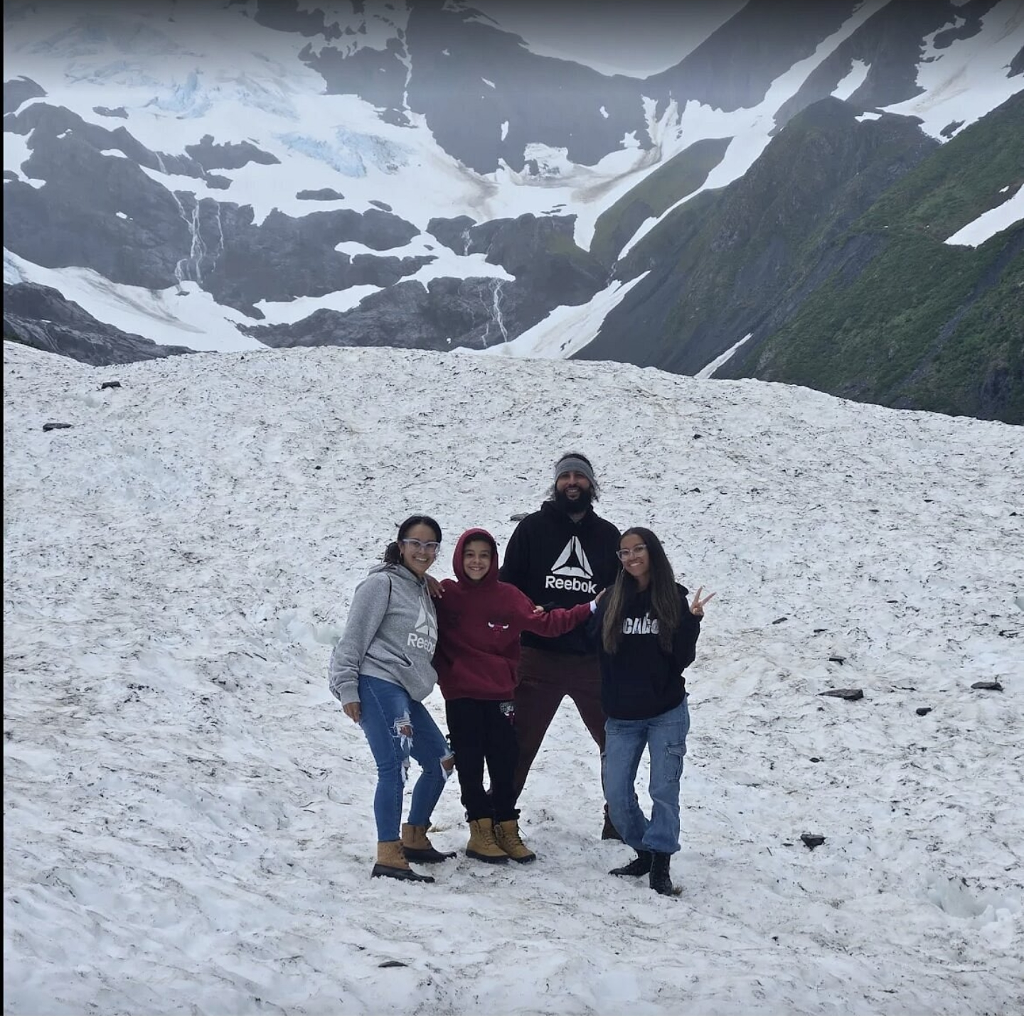 Family on the snowfield below a glacier
