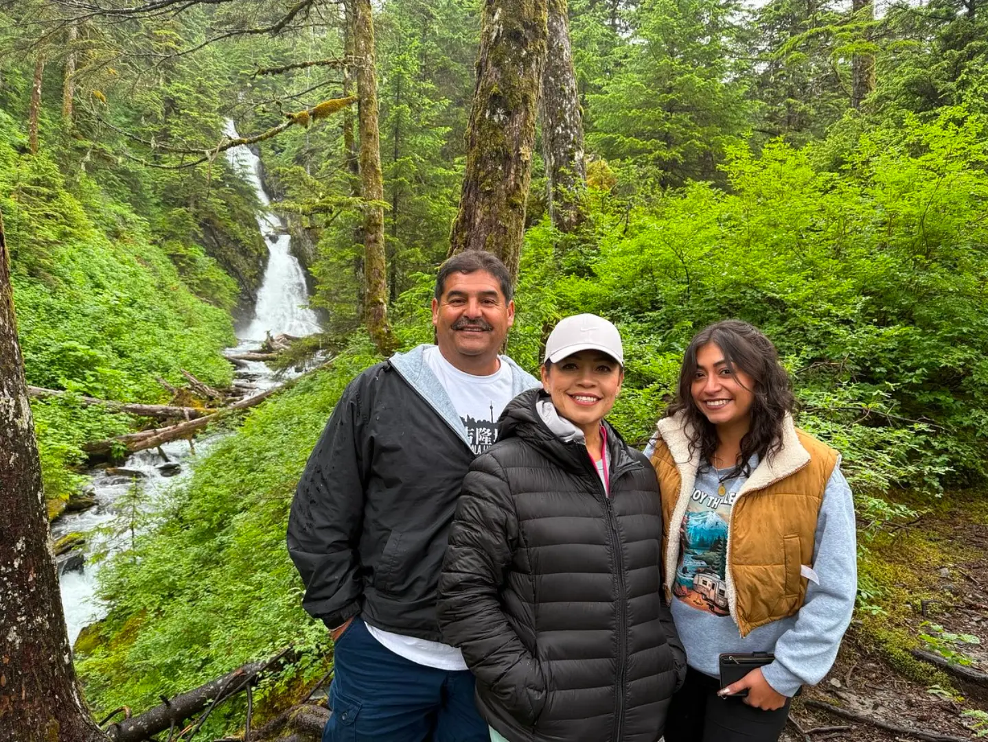 Tour guests by a waterfall in the Girdwood rainforest